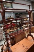 A stained wood towel rail, of traditional design, with plain rails and barley twist columns