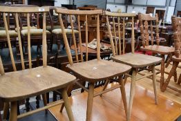 A group of three Ercol style elm seated stick back chairs.