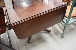 A 19th Century pedestal Pembroke table , in a Regency style , having drawer and dummy to each