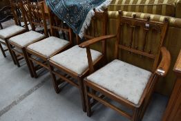 A set of four plus one carver 20th century oak dining chairs having gothic arch back designs