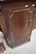 A Georgian corner cabinet with three shelves, key present.