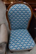A balloon back nursing chair on castors having later needle point upholstery.