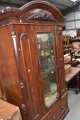 A Victorian mirror door wardrobe having drawer base