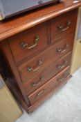 A modern hardwood chest of 2/3 drawers, of traditional design with brass bale handles.