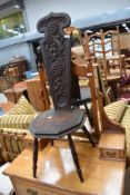 A traditional dark oak spinning chair