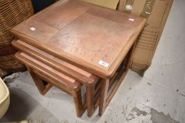 A vintage teak and tile top nest of three tables