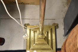 A traditional brass standard lamp, with modern shade