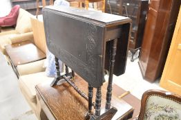 A Victorian dark stained gateleg occasional table having carved decoration