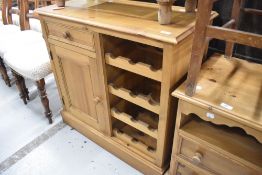 A modern pine wine rack , with space for 12 bottles, and cupboard to side