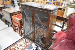 An early 20th Century mahogany display cabinet having astral glazed doors and bracket feet