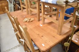 A traditional pine kitchen dining table and set of six ladder back chairs