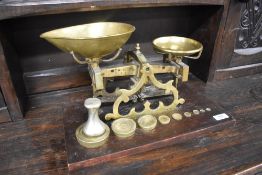 A set of brass balance scales on wood base, with weights