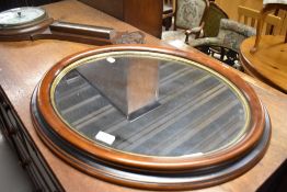 A reproduction mahogany oval wall mirror