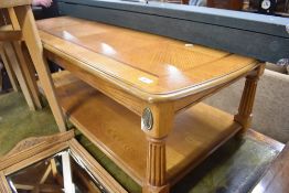 A reproduction coffee table in a light stain, classical style