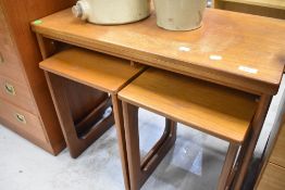 A vintage teak nest with castors