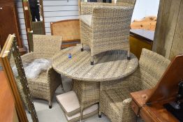 A selection of wicker effect conservatory furniture comprising table and four chairs