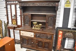 A period oak dresser having court cupboard style back section, naively carved decoration and