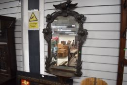 A 19th Century wall mirror in the Black Forest style with carved phoenix and nuts or fruit etc