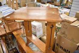 An Arts and Crafts golden oak drop leaf standing table having twist top, in the Arthur Simpson