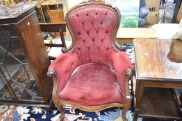 A Victorian button back armchair having dralon uphostery on scroll frame