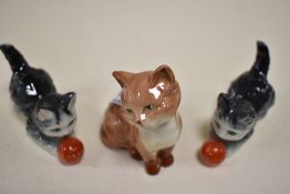 Three cat figures including Beswick seated cat and two Geobels cats playing with ball