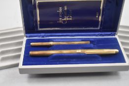 A Christian Dior gold plated fountain pen and ballpoint pen set in original box