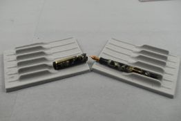 A Mentmore Auto Flow leverfill fountain pen in black and grey marble with single narrow band to