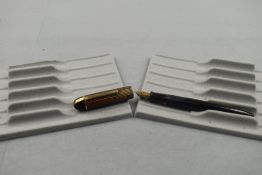 An Eversharp leverfill fountain pen in black with red and yellow striped cap having Eversharp 14ct