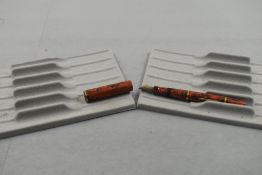 A Mabie Todd Swan 130B 61 Clipless Ladies fountain pen in orange and black with two bands on the