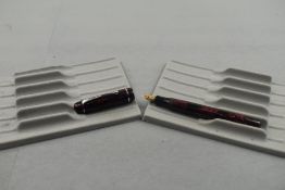A Mentmore button fill fountain pen in black and pink marble with single narrow band to the cap