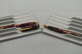 A Conway Stewart 84 leverfill fountain pen and propelling pencil set in rose pink marble having