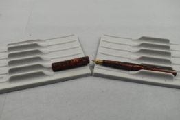 A Mabie Todd Swan leverfill clipless fountain pen in woodgrain orange and black having Swan 1 nib.