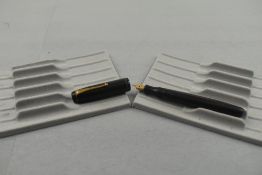 A Mentmore Auto Flow button fill fountain pen in black with single narrow band to the cap having