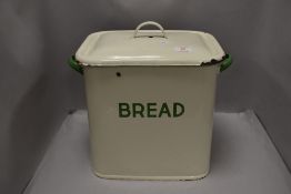A vintage enamelled bread bin with cover, of traditional design, text and handles in green.