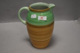 An art deco water jug having two tone green on brown glaze by Shelley