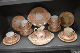 A late Victorian porcelain part tea service having pink ground with gilt details and hand painted