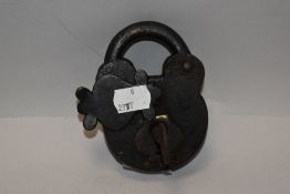 An antique iron padlock, of traditional design with hooped shank and hand forged body and pivoted