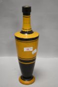 An antique Italian wine or oil bottle having black and yellow body