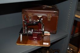 A 20th century working toy miniature sewing machine by Essex with case and instructions