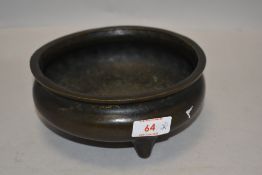 A Chinese bronze temple censor or incense burner of plain form with three footed base bearing seal