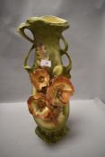 A continental pottery vase, of Art Nouveau design and decorated with flowers, foliage and seed