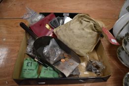 A selection of bankers collectable coins and currency with a coin shovel and a large bag of pennies