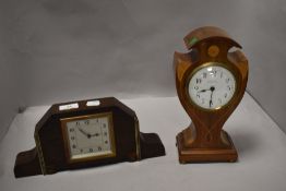 An Edwardian inlaid mahogany balloon form mantel clock, the enamelled dial with Arabic hours and