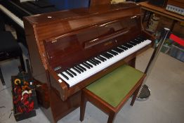 A modern upright piano, labelled Zender and a stained frame stool