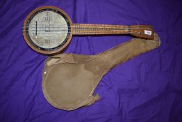 A traditional early 20th Century banjo ukulele , in canvas bag