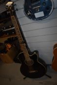 An Ibanez electro acoustic bass , with stand