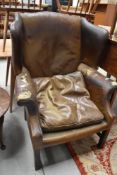 A vintage leather wing armchair