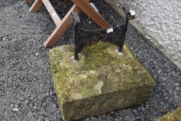 A carved stone and wrought metal shoe scraper