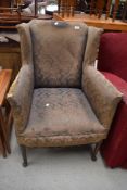 A Howard style wing back armchair, in need of upholstery
