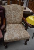 A reproduction Queen Anne style armchair having ball and claw feet